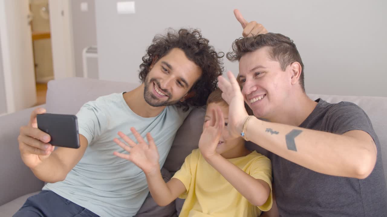 Due padri felici e un bambino che fanno una videochiamata