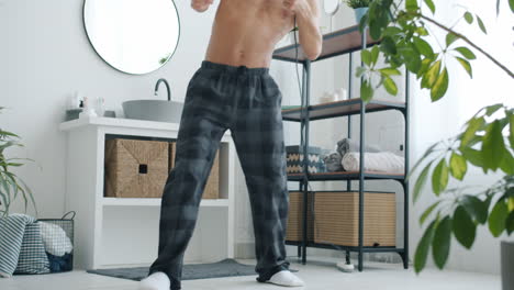man dancing with hair dryer in bathroom