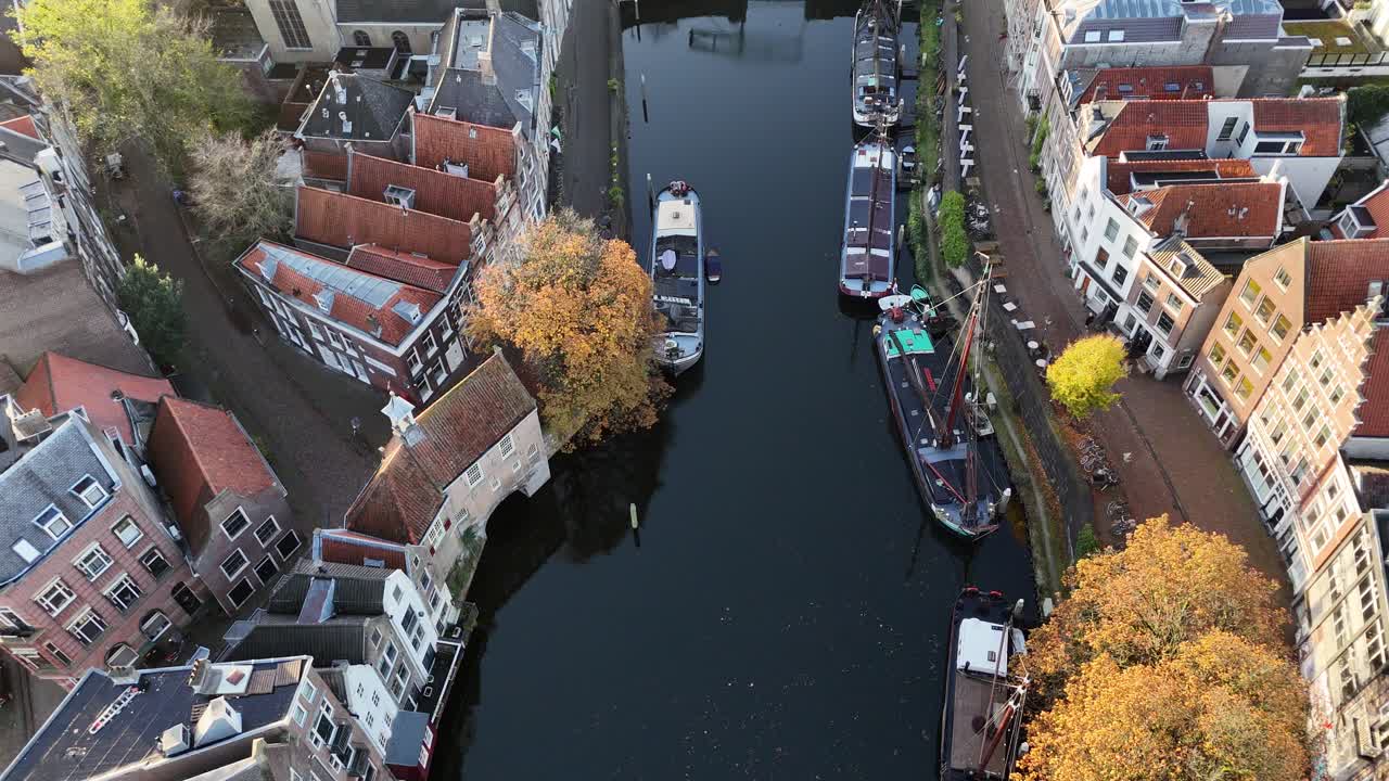 Drone footage of Rotterdam, Netherlands, showing the unique perspective of canal-side buildings, vibrant fall trees, and the reflective water—capturing the beauty of the city’s architecture + canals