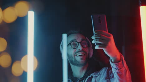 man taking selfie under neon lights