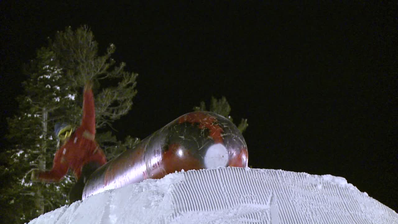 сноубордист скользит на вершине металлического цилиндра