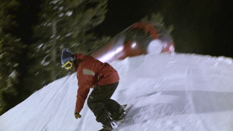 a snowboarder slides on top of a metal cylinder