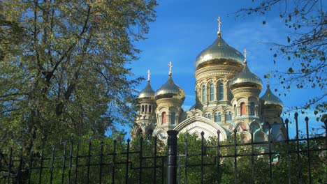 view of orthodox st nicholas naval cathedral golden domes and crosses on blue sky in sunny autumn day at karosta, liepaja, wide shot