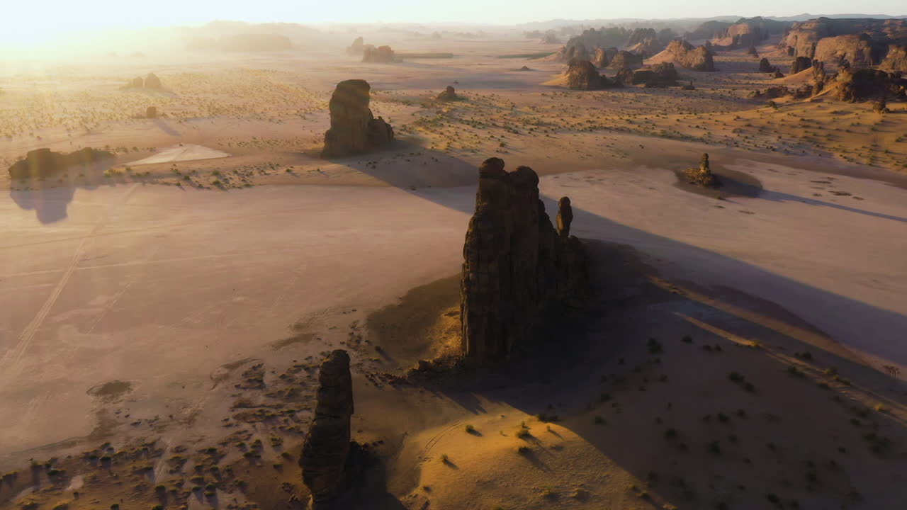 Ripresa aerea in tilt che si affaccia su scogliere di arenaria, serata soleggiata nei deserti dell'Arabia Saudita