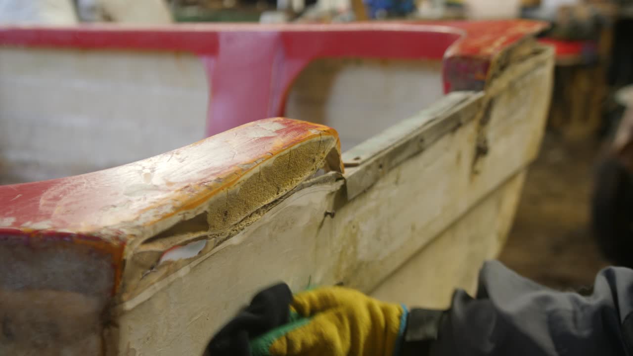 Pulizia di una barca in vetroresina danneggiata per il processo di riparazione