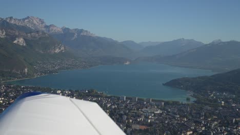 lake annecy in the french alps with village, aerial airplane side shot