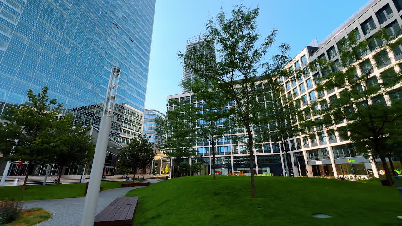 Modern urban park in a sleek city area. Bright sunny day in a contemporary urban park surrounded by glass buildings and green landscaping
