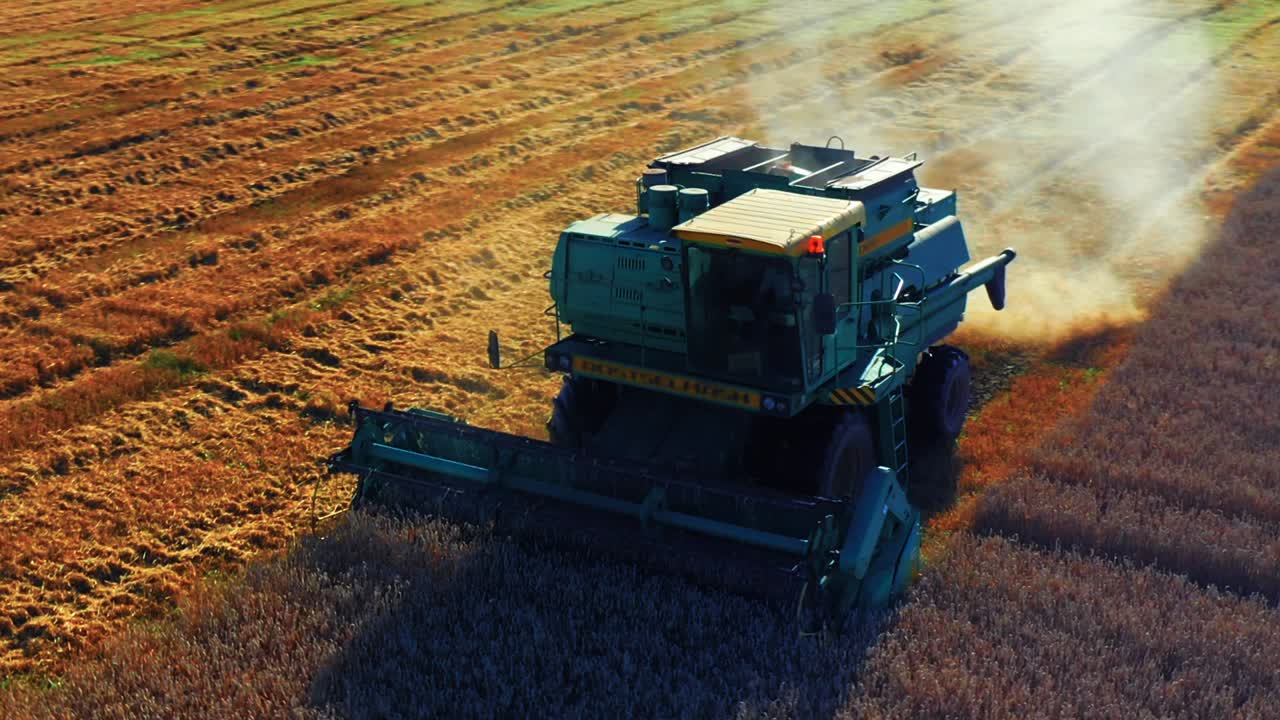 A Combine Harvester Collecting And Harvesting Crop In The Field In Lithuania - drone shot