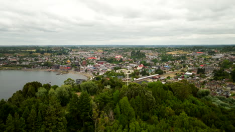 puerto varas on shore of lake llanquihue, cerro calvario hill, with cross, los lagos region, patagonia, chile. aerial forward, copy space