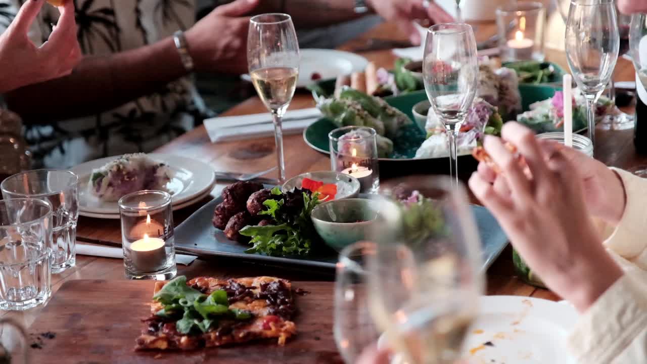 People enjoy a feast around a table eating and drinking