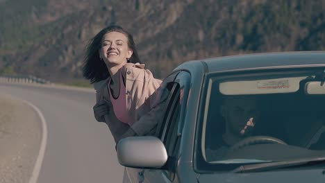 teenage girl in top looks out of car smiles and rejoices