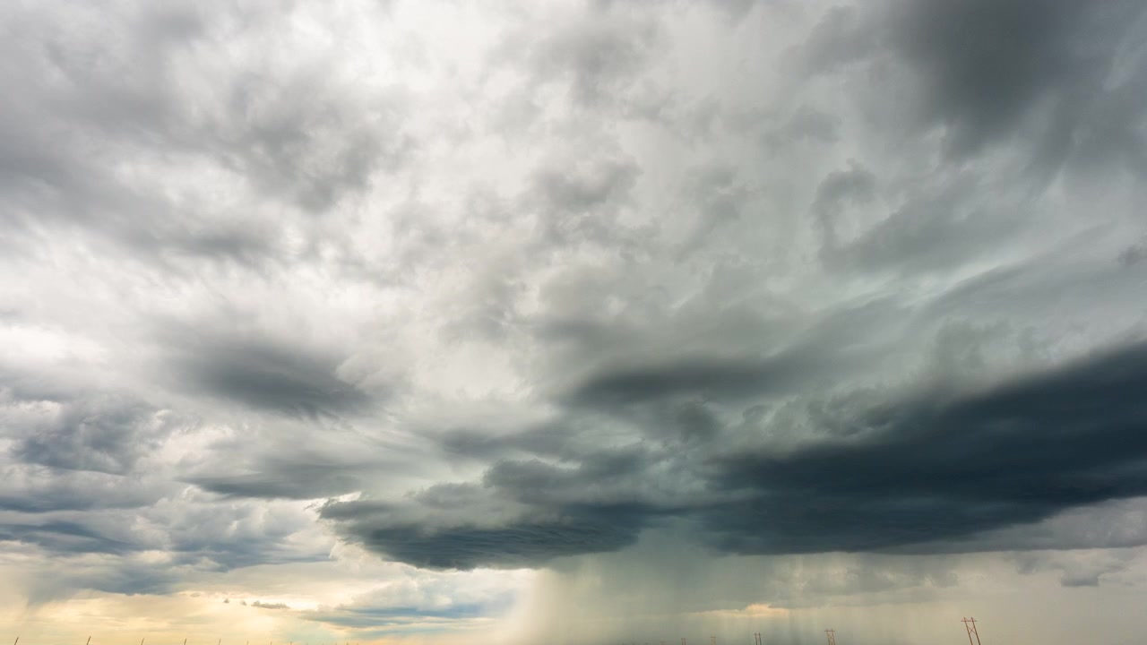 Mørke stormskyer bevæger sig hen over himlen i en dramatisk time-lapse vejrbaggrund.