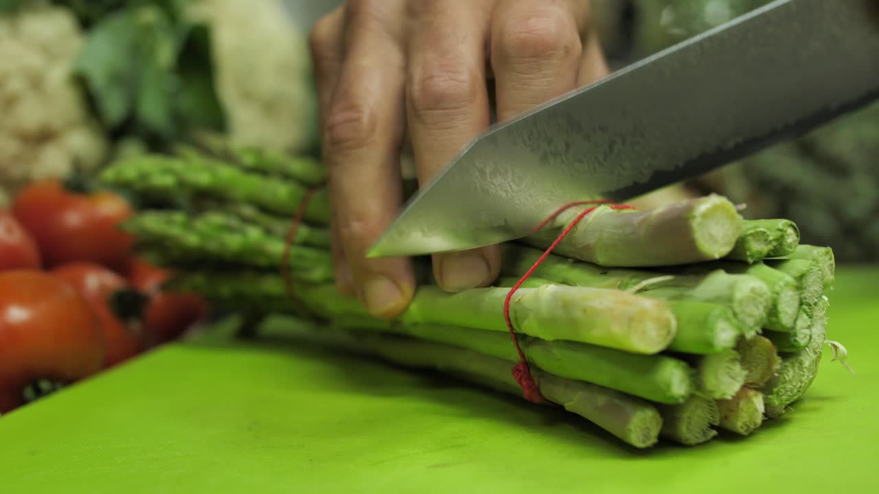 Close up on bunch of asparagus cut by chef in restaurant kitchen