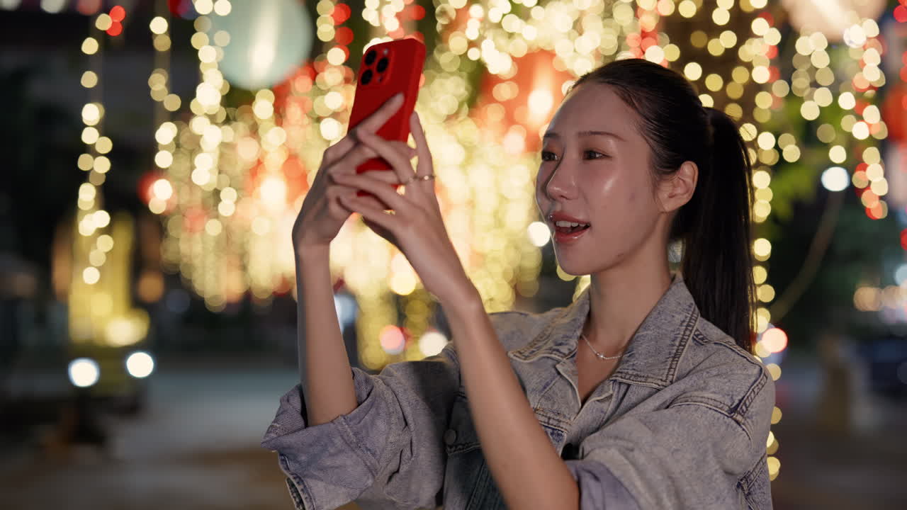 Woman taking a selfie at night with festive lights