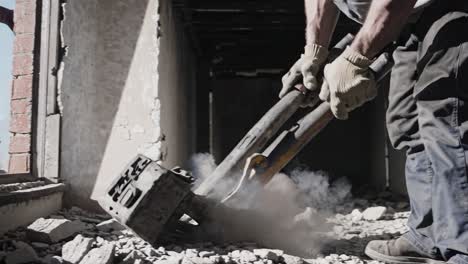 demolition worker using hydraulic breaker