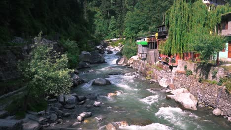 una toma deslizante del viejo puente manali del río manalsu que fluye por el valle