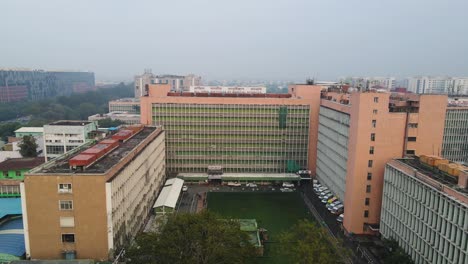 aerial drone shot capturing the daily activity around aiims, with busy roads, hospital buildings, and medical staff in motion.