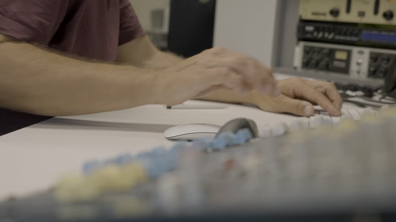 persona controla equipos de audio en estudio profesional, vista de cerca