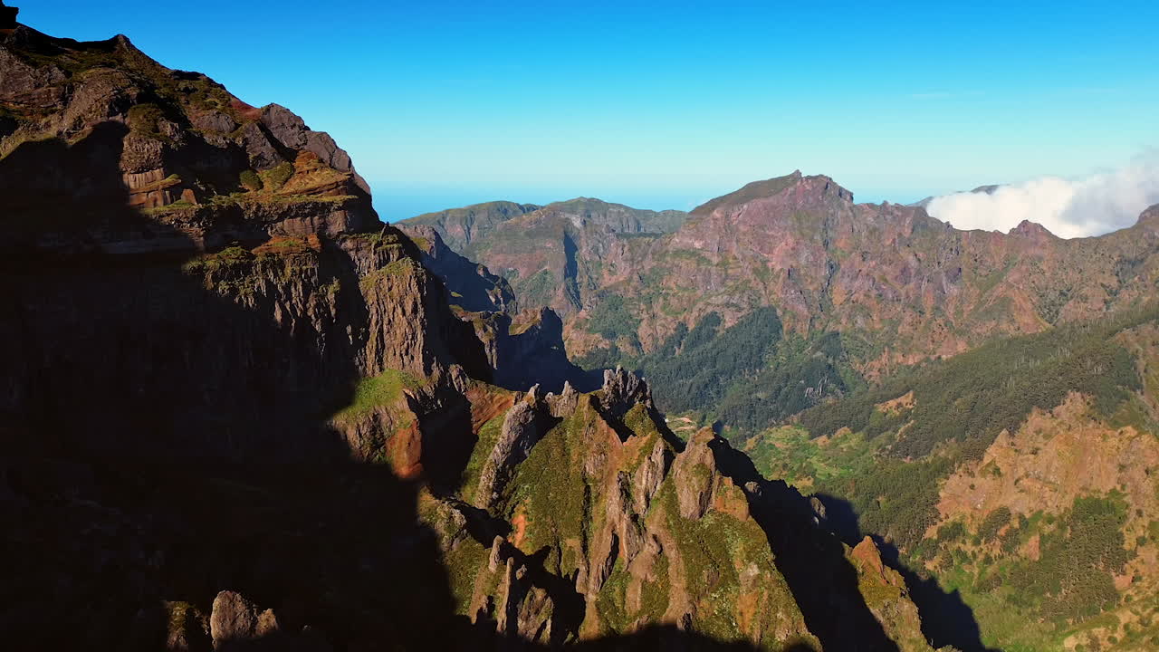 Spectacular mountains with sharp peaks. Sun lighting the slopes of the rocks. Azure sky at backdrop.