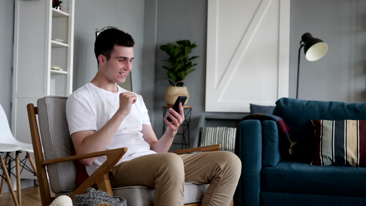 스마트폰을 사용하는 동안 성공에 흥분한 남자