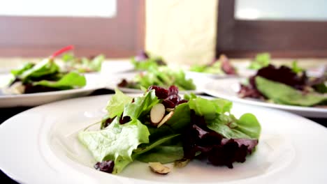 Hands-putting-chopped-almonds-and-blueberries-at-a-salad-banquet