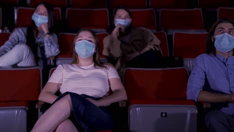espectadores con máscaras en el teatro