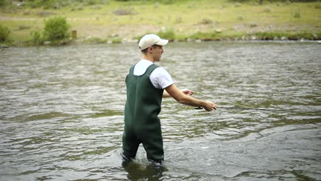 slow motion shot of a caucasian male fisherman casting his hook while fly fishing-13