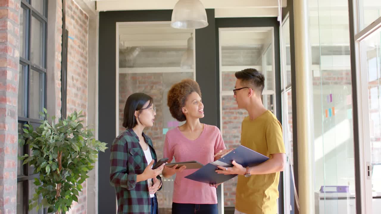 다양한 행복한 남녀 동료들이 통로에 서서 느린 동작으로 일상적인 토론을 하고 있습니다.