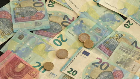 image of 20 and 10 euro banknotes, with several coins falling on the banknotes