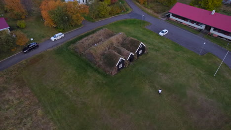 Woman-taking-pictures-of-traditional-Icelandic-viking-houses-in-Holar-village