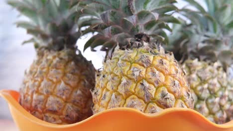 pineapples in an orange bowl