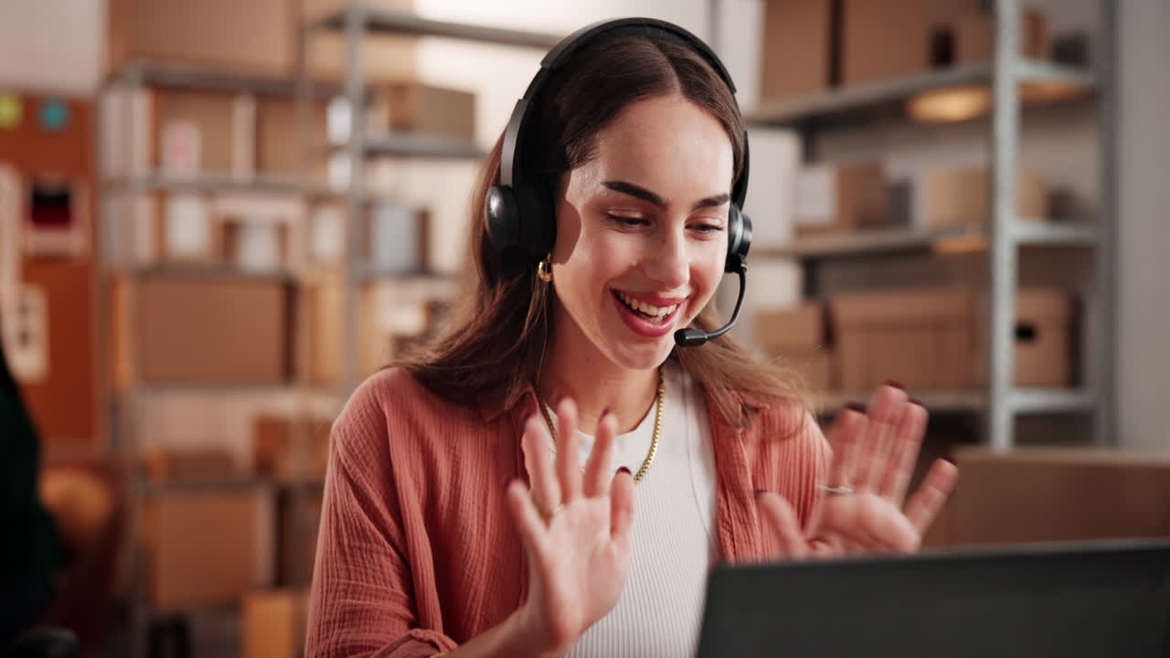 Donna felice con cuffie in videochiamata in un magazzino di e-commerce