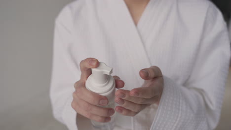 detail of a woman's hands applying foam to her fingers