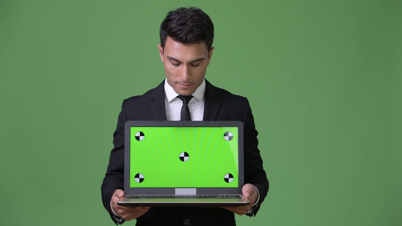 joven y guapo hombre de negocios hispano contra un fondo verde