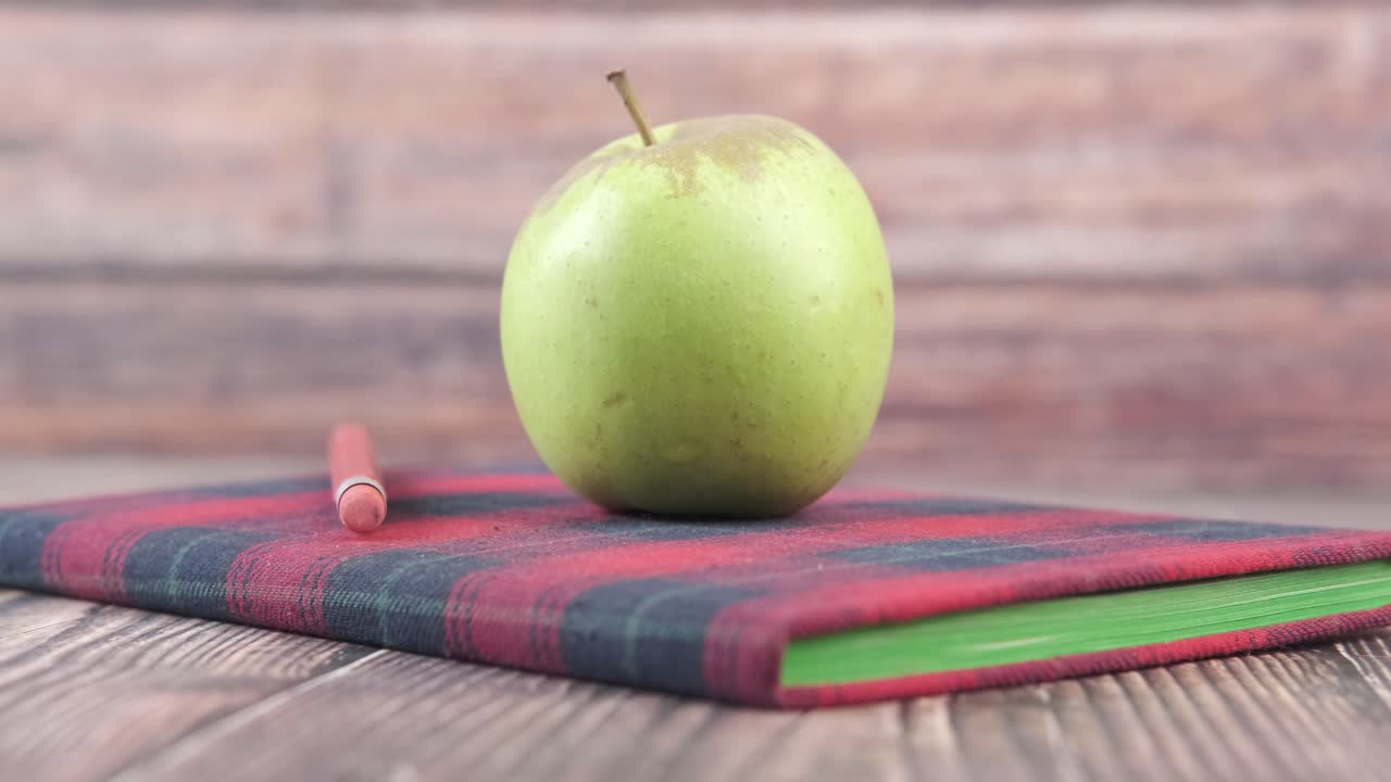 manzana verde en el cuaderno con lápiz