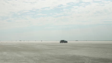 Coche-Solitario-Conduciendo-En-Una-Gran-Playa-En-Fanø,-Esbjerg,-Dinamarca,-VW-Polo-Gris