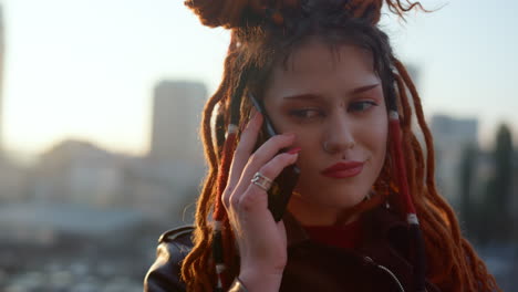 Upset-woman-having-call-at-rooftop.-Serious-girl-holding-mobile-phone-outdoor.