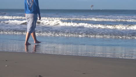 woman walks on the beach and plays in the waves