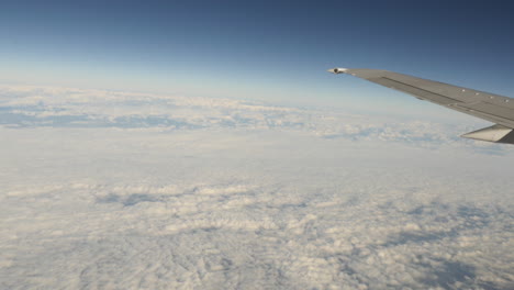 vista aérea de las nubes por la ventana del avión con tiro de ala en 4k de alta resolución