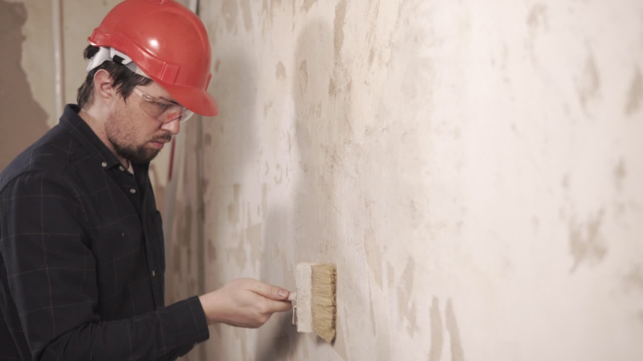 Un operaio che applica il gesso al muro