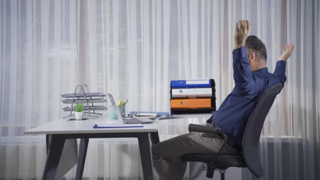 un hombre de negocios maduro que usa una computadora portátil se alegra de las buenas y buenas noticias que ve.