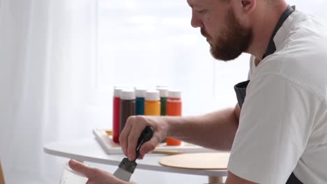 man mixing paint in a studio