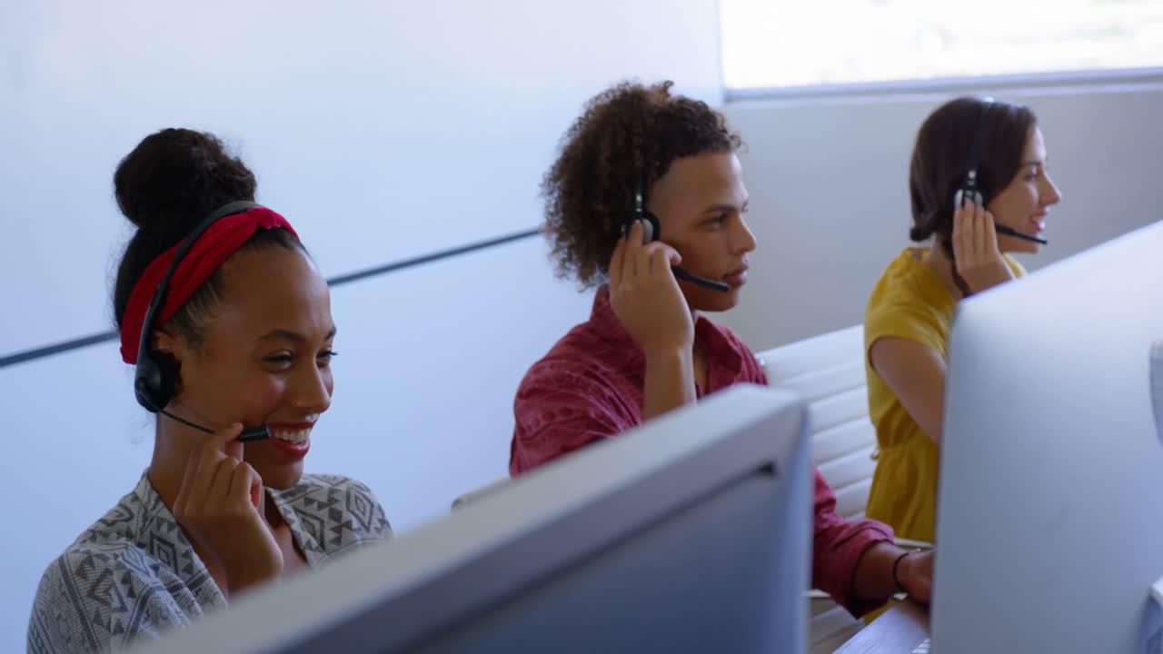 jóvenes ejecutivos de ventas de clientes multiétnicos hablando en auriculares en una oficina moderna 4k