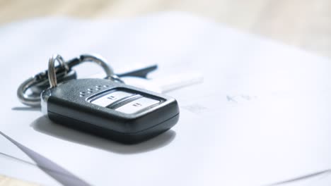 man signs documents with focus on cars key