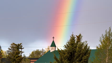 Timelapse-zoom-of-colorful-rainbow-over-church,-pride-blessing-concept