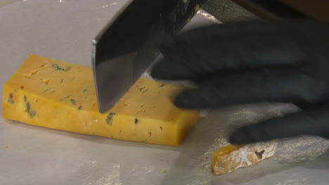 cutting a wedge of blue cheese