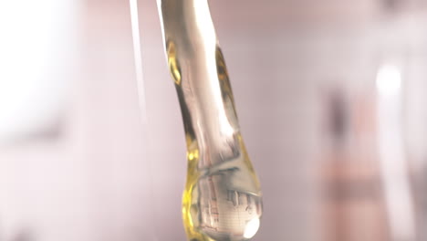 la clara de huevo cruda y la yema de huewo goteando en macro, el huevo cayendo de la cáscara agrietada en cámara lenta