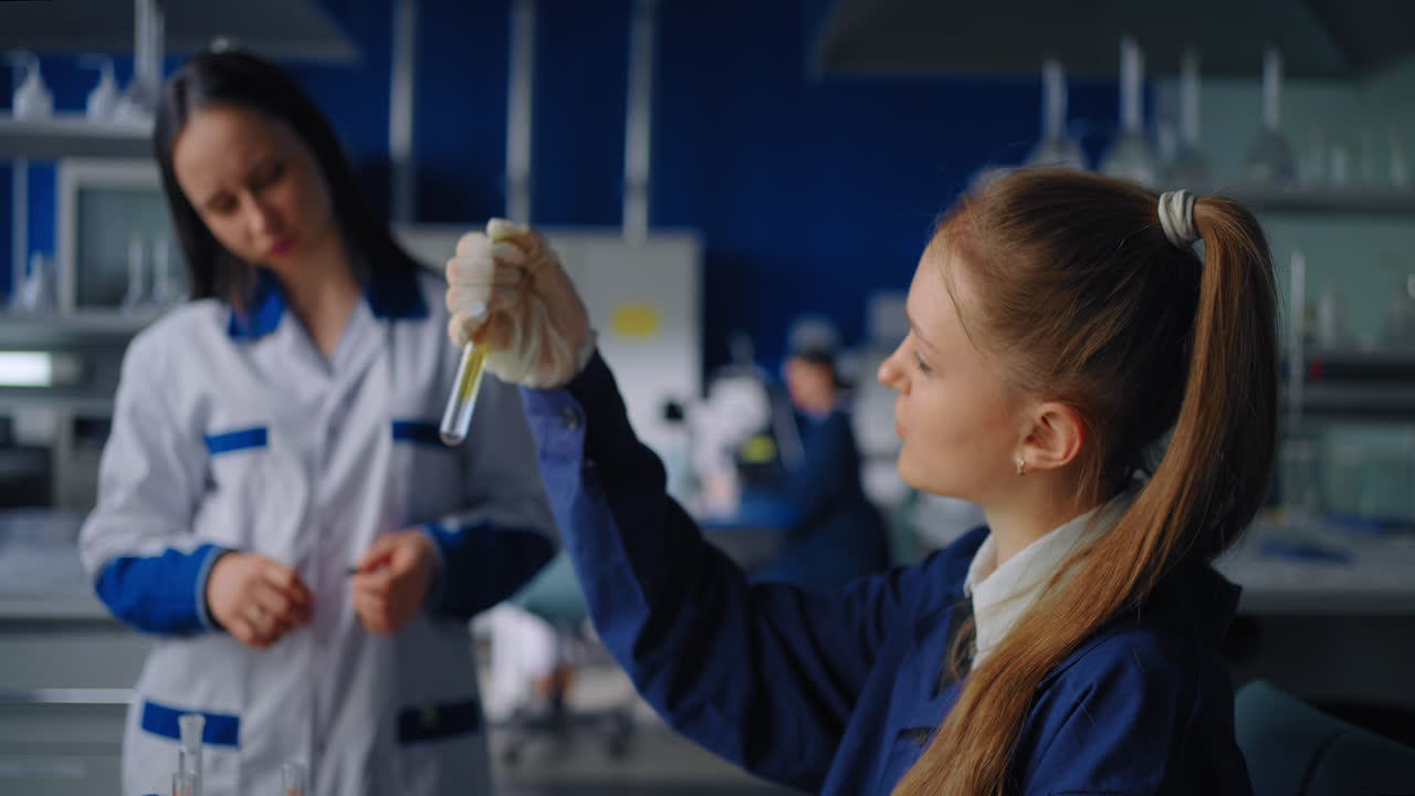 científicos examinando un líquido en un tubo de ensayo en un laboratorio.