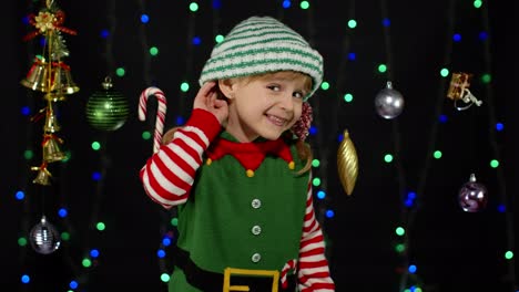 Girl-in-Christmas-costume-keeps-hand-near-ear-tries-to-overhear-what-present-parents-going-to-give