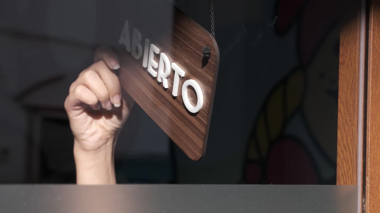 Small business opening up. Turning the sign from close to open in spanish. 4k 60fps